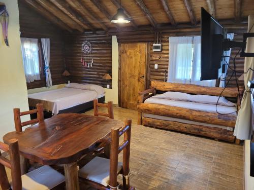 a room with two beds and a table and a tv at Alma de Algarrobo in San Javier