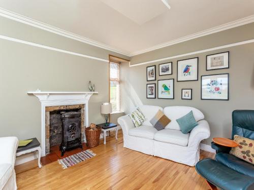 a living room with a white couch and a fireplace at The Laurels in Nairn
