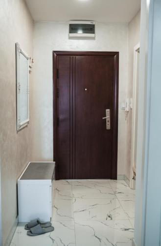 a brown door in a room with a tile floor at Apartman Centar in Doboj