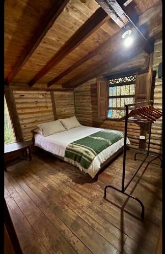 a bedroom with a bed in a wooden cabin at Casa Aurea in Medellín