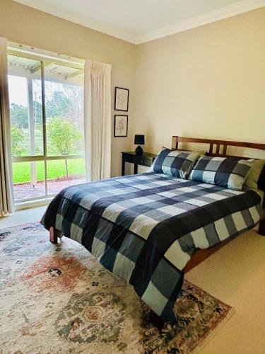 a bedroom with a bed and a large window at Roses Farmhouse in Heathmere