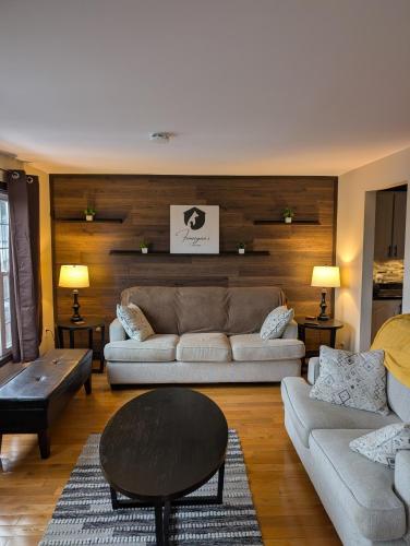a living room with two couches and a table at Finnegan's Cottage in Placentia
