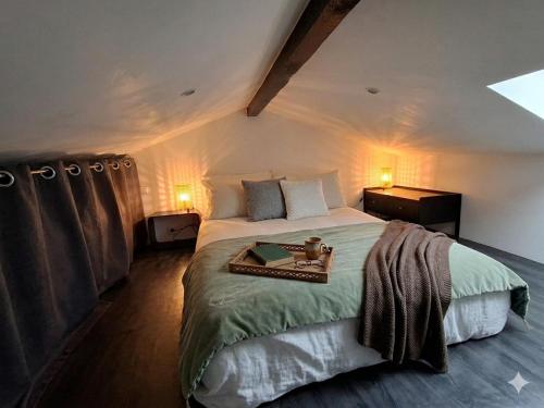 a bedroom with a large bed with a tray on it at Studio indépendant avec jardinet in Tarnos