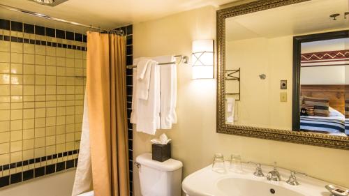 a bathroom with a sink and a toilet and a mirror at Inn & Spa at Loretto in Santa Fe