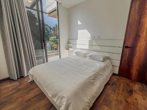a bedroom with a bed and a large window at Upscale 2BR Countryside Suite | Stylish & Modern in El Retiro