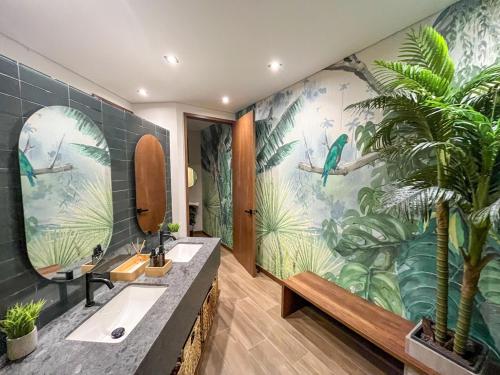 a bathroom with two sinks and a tropical mural at Upscale 2BR Countryside Suite | Stylish & Modern in El Retiro
