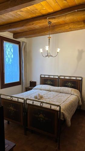 a bedroom with a large bed with a chandelier at Residenza Airone in Vicenza