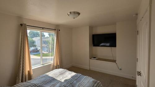 a bedroom with a bed and a tv and a window at Central Mountain Retreat - Sleeps 7! in Logan