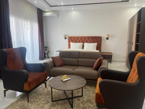 a living room with a couch and chairs and a bed at Hôtel NGOR ALMADIES 4 étoiles in Dakar