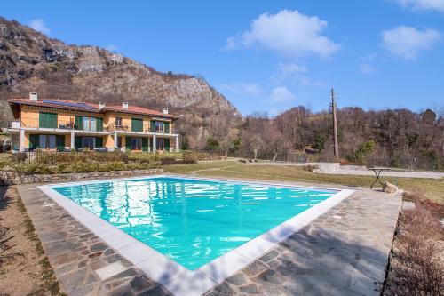 a swimming pool in front of a house at Tremezzo Ulivi Apt.7 in Tremezzo