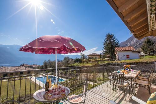 a patio with a table and chairs and an umbrella at Tremezzo Ulivi Apt.7 in Tremezzo