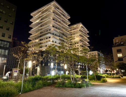 a tall apartment building at night with lights at Appartement Uptown CFC - Piscine - Gym - Parking Gratuit in Casablanca