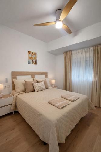 a bedroom with a large bed with a ceiling fan at Alojamiento Baeza - Leones 9 A in Baeza