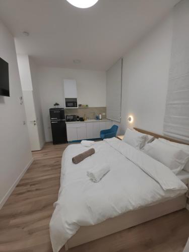 a large white bed in a room with a kitchen at Koresh 10 -revelin suite in Jerusalem