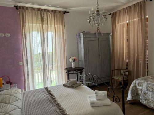 a bedroom with two beds and a chandelier at B&b Oca Carolina in Buttigliera Alta