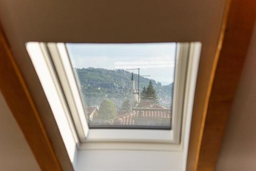 a window with a view of a train at Carmen Old Town Apartments in Sarajevo