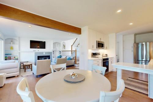 a kitchen and living room with a white table and chairs at Lakeshore Retreat in Gilford