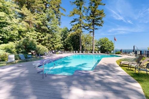 an empty swimming pool with chairs and trees at Lakeshore Retreat in Gilford