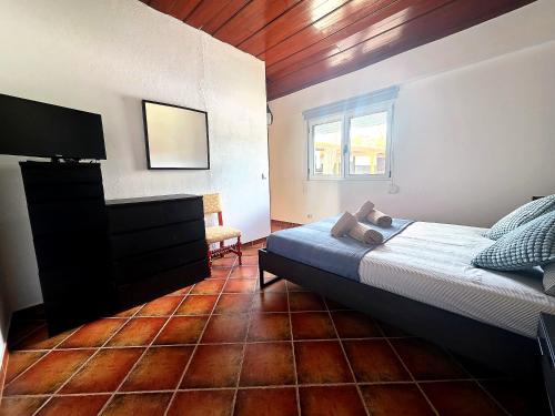 a bedroom with a bed and a flat screen tv at Villa 7 - Vale do Lobo in Almancil