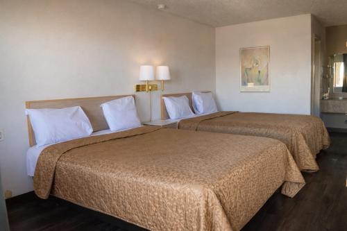 two beds in a hotel room with two beds at Tree Inn & Suites Albuquerque in Albuquerque