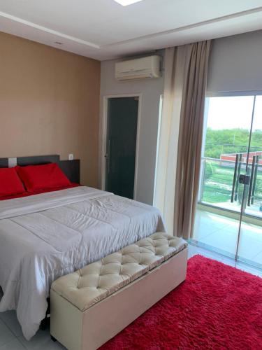 a bedroom with a white bed and a red rug at Apartamento panorâmico com 2 suítes 1 quarto in Petrolina