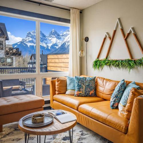 a living room with a couch and a view of mountains at Alpine Oasis at Alpine Village in Canmore