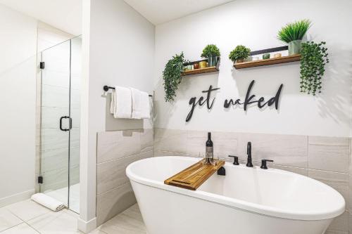 a bathroom with a white tub and plants on the wall at Inspired Elegance at Tamarack Lodge in Canmore