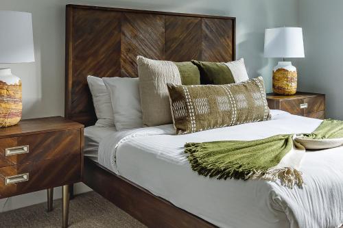 a bedroom with a bed with a wooden headboard and pillows at Inspired Elegance at Tamarack Lodge in Canmore