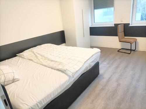 a bedroom with a bed and a chair in it at Waldstreet in Rüsselsheim