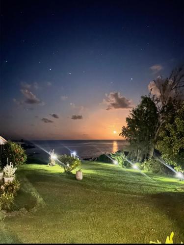 a yard with a view of the ocean at night at Caribbean Lotus in Le François