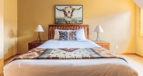 a bedroom with a bed with a cow picture on the wall at Utopia at Rundle Cliffs Lodge in Canmore