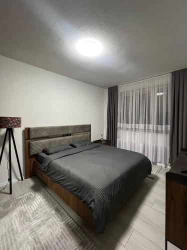 a bedroom with a large bed and a window at Cozy Central Corner in Gjakove