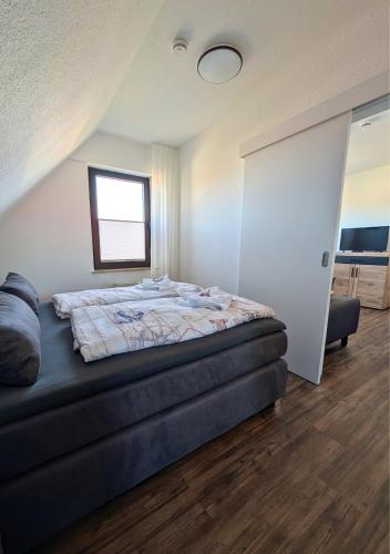 a bedroom with a bed and a window at Haus Ausreißer 2 - Heimathafen in Bensersiel