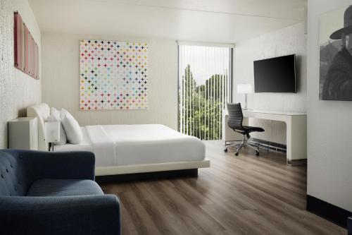a white bedroom with a bed and a desk and a tv at The Clarendon Hotel & Spa, BW Signature Collection in Phoenix