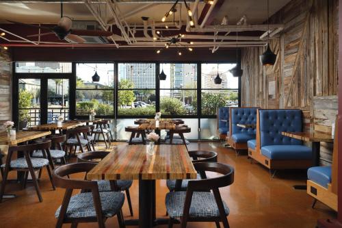 a restaurant with wooden tables and blue chairs at The Clarendon Hotel & Spa, BW Signature Collection in Phoenix