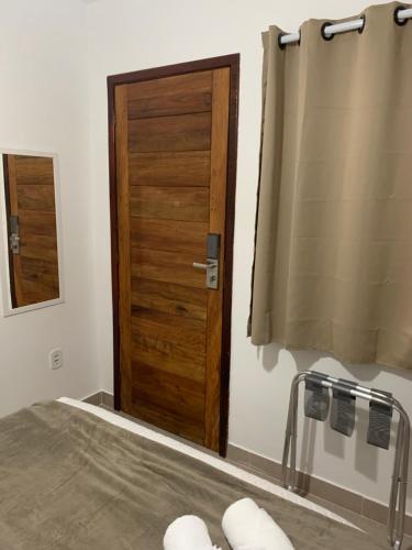 a wooden door in a room with a curtain at Pousada Reserva de Itaúna in Saquarema