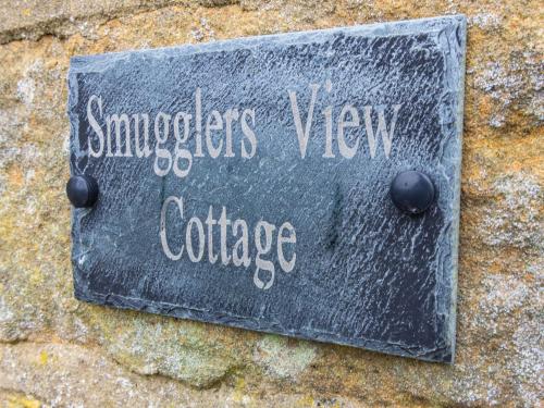a sign on the side of a stone wall at Smugglers View Nr Whitby in Ravenscar