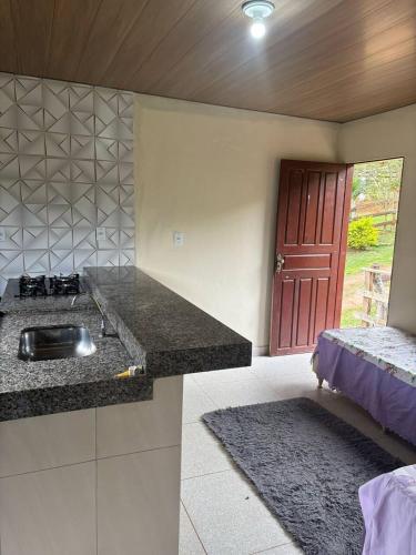 a kitchen with a sink and a bed in a room at Chalé do Vicente in Ouro Preto