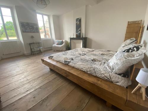 a large bed in a room with a wooden floor at Chambre zen in Châteauneuf-sur-Charente