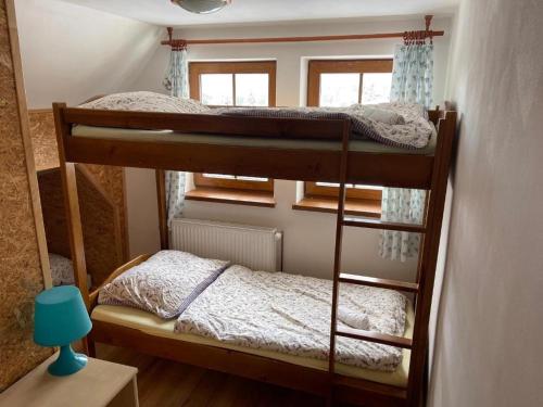 two bunk beds in a small room with a lamp at Hepnarova Bouda in Horní Malá Úpa