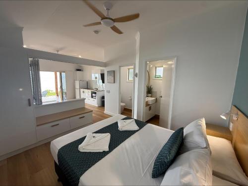 a bedroom with a bed and a ceiling fan at Ellis Beach Oceanfront Holiday Park in Palm Cove