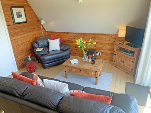 a living room with a couch and a table at Glenlivet View in Auchnastank