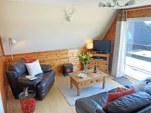 a living room with a couch and a coffee table at Glenlivet View in Auchnastank
