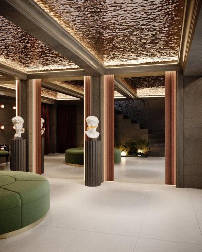 a lobby with columns and green chairs and a ceiling at Hotel Bela Kuka - White House in Bitola
