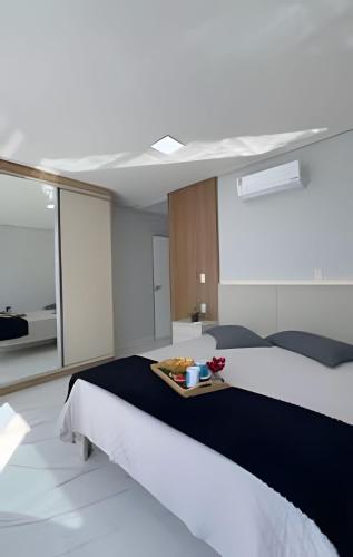 a bedroom with two beds and a tray of food at Apto Lavandas|2Qts.Lado Centro Eventos,150m Termas in Piratuba
