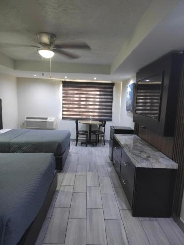 a hotel room with two beds and a table at Hotel Siesta Real in Mexicali