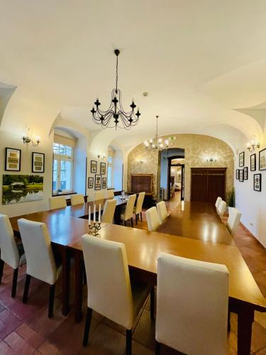 a dining room with a large wooden table and chairs at Hotel Zámek Berchtold in Kunice