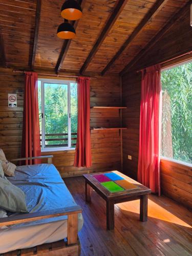 a bedroom in a log cabin with a bed and a table at Cabañas Amo Río - Delta in Tigre