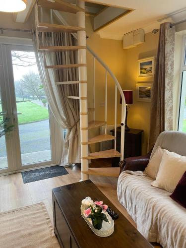a living room with a couch and a spiral staircase at Tourmakeady Self Catering in Toormakeady