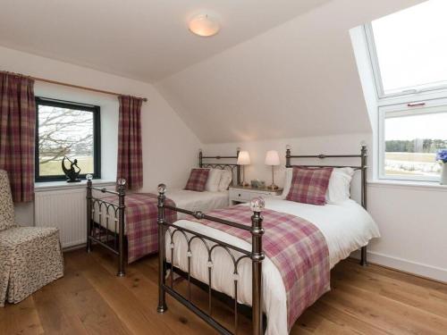 a bedroom with two beds and a window at Millbank in Ballindalloch